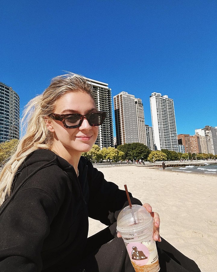 Kelsea Sips Smoothie On Beach In Black Hoodie [Kelsea Ballerini | Instagram]