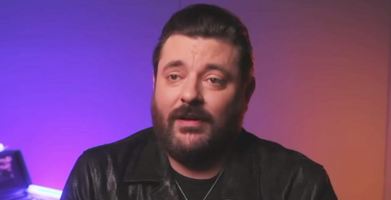 A man with brown hair and a bushy brown beard.