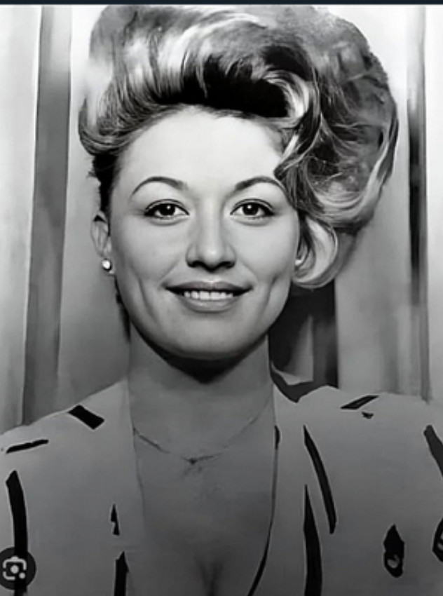 A black and white photo of a woman with her hair styled in curls around her face